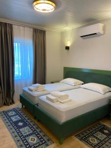 Këlcyrë“Sarajet” Bed&Breakfast的一间卧室配有两张带毛巾的床