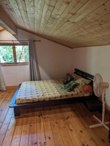 BlésignacGîte zen dans les bois的木天花板的客房内的一张床位