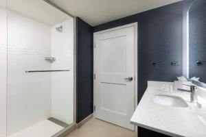 加登城Residence Inn Long Island Garden City的一间带水槽、淋浴和镜子的浴室