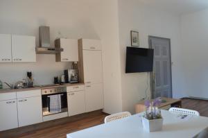 Gemütliche Ferienwohnung - Prein an der Rax的厨房配有白色橱柜、桌子和电视。