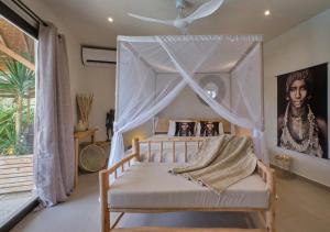 恩加帕鲁Villa Chanalu的一间卧室配有一张带天蓬的床