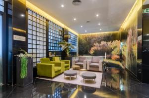 里斯本欧力斯普马克思德萨酒店的大楼内带黄色和绿色家具的大堂