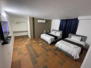 巴耶杜帕尔Hotel Valle Central的酒店客房设有两张床和一台平面电视。