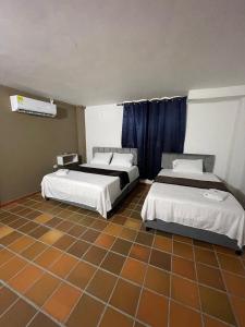 巴耶杜帕尔Hotel Valle Central的一间带两张床的卧室,铺有瓷砖地板。