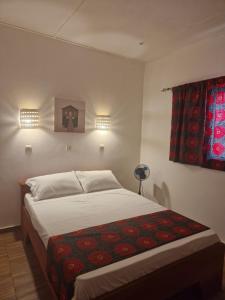 斯基灵角La Cazasamba的一间卧室配有一张床铺,床上铺有红色毯子