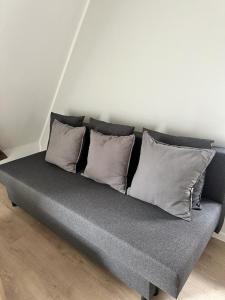 卡尔斯鲁厄Ochsen-Durlach的一张灰色的沙发,上面有四个枕头