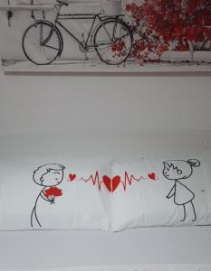 圣潘克拉齐奥萨伦蒂诺Mini Suite Salento的一张带两个枕头的床,有心和自行车