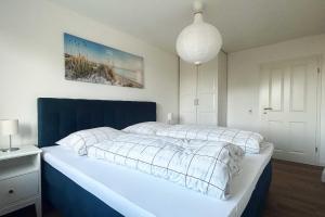 沙博伊茨Residenz an der Ostsee的一间卧室配有一张大床和蓝色床头板