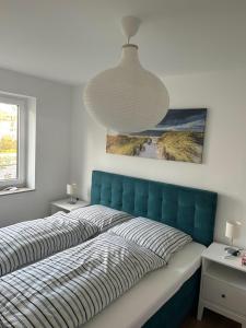 沙博伊茨Residenz an der Ostsee的卧室里一张带蓝色床头板的床