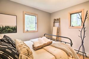 WintergreenSerene Hideaway with Views, 1 Mi to Hike and Ski!的一间卧室设有一张床和两个窗户。