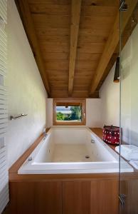 多尔梅莱托拉库彻塔住宿加早餐旅馆的配有木制天花板的客房内的大浴缸