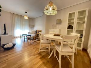 维拉加尔西亚·德·阿劳萨Apartamento Xalda con piscina的用餐室以及带桌椅的起居室。