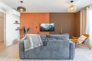 拉萨尔勒班Exceptionnel ! Appart luxueux à 8 min à pied du lagon的带沙发和橙色墙壁的客厅
