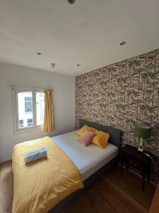 奈梅亨巴巴罗萨旅馆 的一间卧室配有一张带黄色和粉红色枕头的床