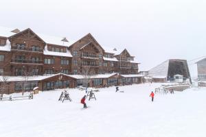 JayJay Peak Village Home 367A&B的一群人在小屋前的雪中滑雪