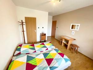 弗瓦迪斯瓦沃沃Promyk的一间卧室配有一张色彩缤纷的床和一张木桌