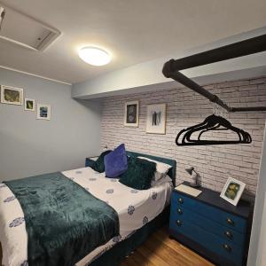 ScorrierRobins nest的一间卧室设有一张床和砖墙