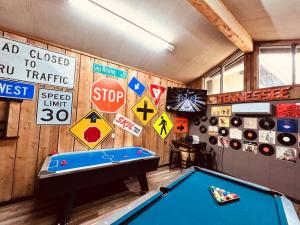加特林堡Bourbon Hollow Lodge with Hot Tub and Pool plus Game Room only 5 min to downtown的一间设有台球桌和墙上标志的房间
