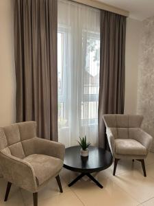 丘普里亚ĆAKA Luxury Rooms & Restaurant的客厅配有两把椅子、一张桌子和一扇窗户