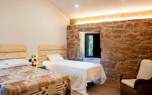 雷东德拉Casa D'Mina的一间卧室设有两张床和石墙