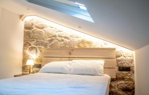 雷东德拉Casa D'Mina的卧室配有白色的床铺和石墙