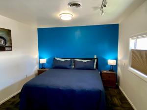 Greybull格雷布尔汽车旅馆的一间蓝色卧室,配有一张床和两盏灯