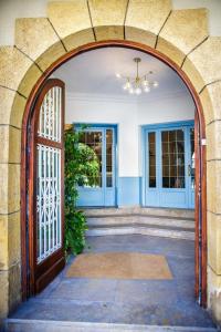 坎布里尔斯Hotel Can Solé的通往带蓝色门的房子的拱门入口