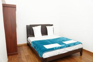 拜蒂克洛Nilo's Guest House的一间卧室配有一张带蓝色毯子的床