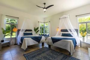 白豪斯Ivy's Cove Beach Side Condo - Luxury Villa的带窗户的客房内的两张床