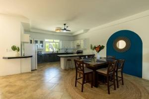 白豪斯Ivy's Cove Beach Side Condo - Luxury Villa的厨房以及带桌椅的用餐室。