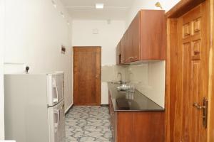 拜蒂克洛Nilo's Guest House的厨房配有水槽和冰箱