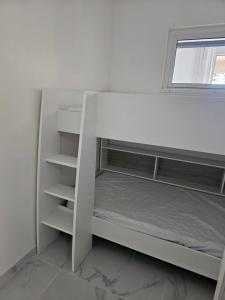 滨海卡瓦莱尔Appartement 2 chambres的窗户客房内的一张白色双层床