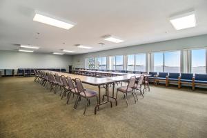 米尔斯Dunes Waterfront Resort的大型会议室,配有长桌子和椅子