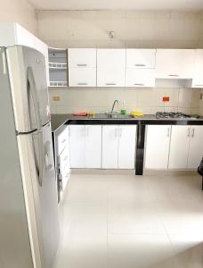 托卢Casa a una cuadra del mar的厨房配有白色橱柜和冰箱。