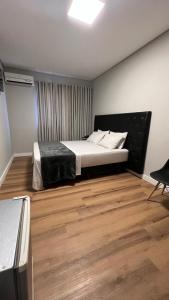 圣保罗钻石酒店的一间卧室配有一张床,铺有木地板
