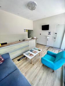 巴兰基亚Hostal Lumar的客厅配有蓝色的沙发和电视
