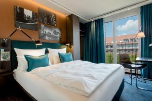 汉堡Motel One Hamburg-Fleetinsel的卧室设有一张白色大床和一扇窗户。