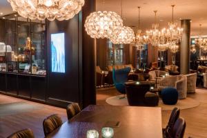 柏林文柏林贝勒福汽车旅馆的餐厅设有桌椅和吊灯。