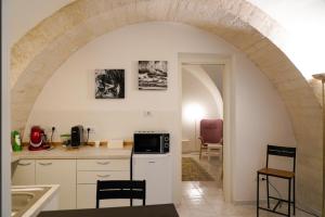焦维纳佐Arco Felice的带拱门的厨房和带白色橱柜的厨房