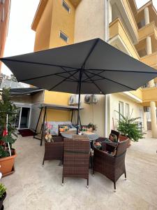 乌尔齐尼Apartments Edona的一张桌子和椅子上方的大型黑伞
