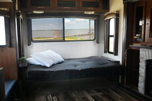 Bolivar PeninsulaBay View Glamping的一张位于火车后部的带窗户的床铺
