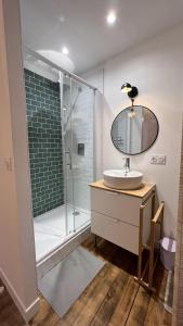 Thury-HarcourtAppartement au coeur de la Suisse normande的浴室配有盥洗盆和带镜子的淋浴