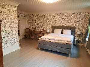 LarvSjötorps Säteris 1600-tals Huvudbyggnad的一间卧室配有一张床和花卉壁纸