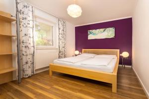 皮森多夫埃姆太斯齐尔利恩公寓的一间卧室配有一张床和紫色的墙壁