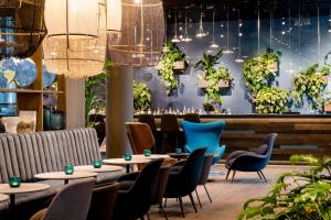 波恩Motel One Bonn-Hauptbahnhof的餐厅设有桌椅和吊灯。