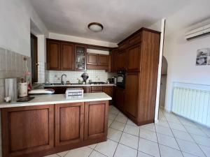 阿夸维瓦Casa Isidora的厨房配有木制橱柜和白色瓷砖地板。