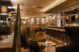 曼彻斯特曼彻斯特皇家交易所墨泰旺酒店的餐厅设有酒吧,配有皮革桌椅
