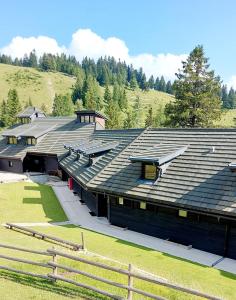 戈雷尼斯卡地区采尔克列Apartma Krvavec - cosy mountain retreat的一座大型建筑,设有大型屋顶和田野