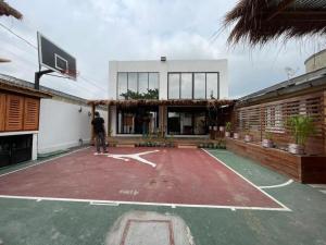 布拉柴维尔Wowo Loft Residence的站在一座建筑前面的篮球场上的人