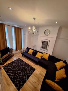 滨海绍森德B&T Pleasure Homes - Southend的客厅配有沙发和墙上的时钟